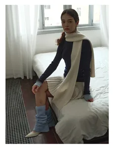 Detailed knit texture of a soft wool scarf paired with a warm sweater and pleated skirt