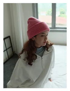 Textura detallada del gorro de punto rosa 100% lana de oveja con diseño de tejido de canalé