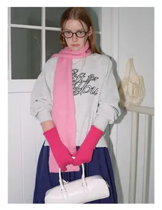 Detail van roze gebreide wollen sjaal gecombineerd met een grijs sweatshirt