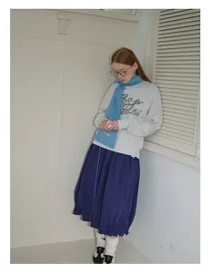 Detailansicht eines hellblauen Alpaka-Wollschals kombiniert mit einem grauen Sweatshirt