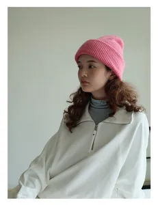 Detalle de gorro de lana rosa con textura de punto en modelo para moda de invierno