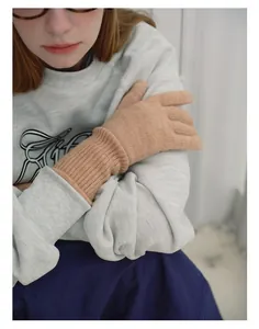 Close-up of soft peach wool blend knit gloves featuring elastic ribbed cuffs for women