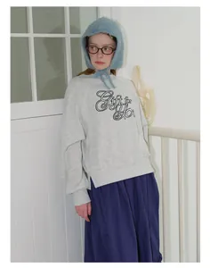 Detail view of blue mohair knit hat with ties styled with a grey sweatshirt