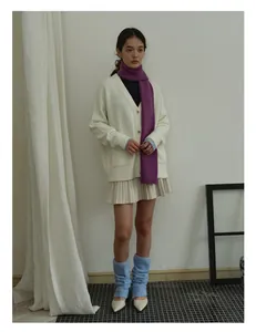 Detail of soft purple wool scarf paired with a white knit cardigan and blue leg warmers