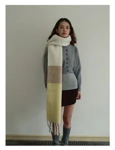 Détail d'écharpe en laine épaisse à blocs blanc, kaki et jaune avec de longues franges