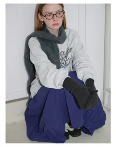 Chic winter style featuring dark grey knit gloves paired with a grey sweatshirt and blue skirt