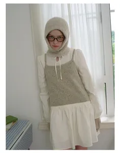 Close-up of light grey-green wool blend boucle balaclava and matching knit vest for women