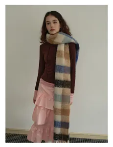 Blue plaid wool scarf styled with a brown hoodie and pink skirt for a winter layered look