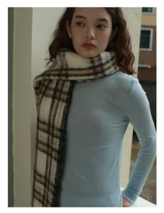 Close-up of brown and white checkered wool blend scarf with soft plush texture