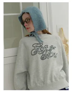 Detailed view of gray sweatshirt paired with soft blue mohair knit hood accessory