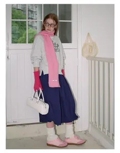 Winter outfit featuring wool blend pink knitted gloves and a matching scarf on a model