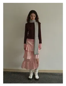 Fashionable grey knitted wool scarf paired with pink tiered skirt and brown hoodie