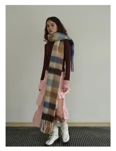 Detail of soft 40% wool plaid scarf with fringes in blue, beige and brown tones