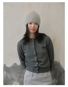 Détail du cardigan en laine gris foncé avec boutons et bonnet en maille assorti