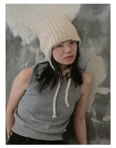 Detailed knit texture and cat ear design of the cream alpaca blend beanie with ties