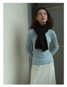Chic winter style featuring a pure black wool knit scarf styled with a light blue sweater