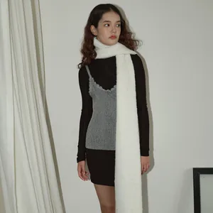Minimalist wool blend scarf styled with a long black dress and grey layered vest
