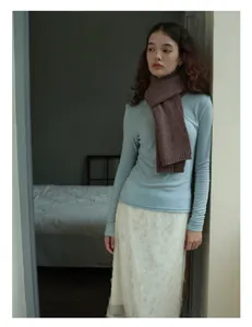 Close-up of thick brown knit wool scarf paired with a light blue long sleeve sweater