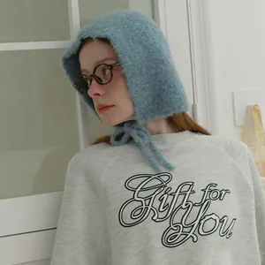 Soft sky blue chunky knit balaclava with ties paired with a cozy white fleece sweatshirt