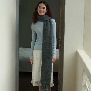 Gray wool blend knit scarf with tassels shown on model for a cozy winter outfit