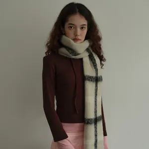 Plaid wool blend scarf in deep red and cream styled with a knit sweater for winter