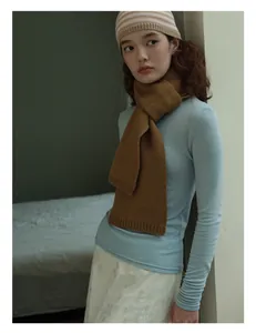 Close-up of caramel wool scarf showing fine knit texture and ribbed edge detail