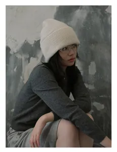 Primer plano detallado de la suave textura de punto acanalado blanco del gorro de lana