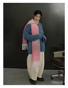 Dettaglio sciarpa in misto lana sfumata rosa con lunghe frange e maglione blu a maglia