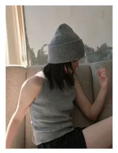 Detalle del gorro de lana gris y chaleco a juego mostrando la suave textura del tejido