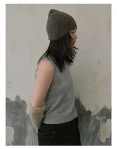 Vue détaillée du bonnet en laine mélangée douce et du gilet gris texturé sur un mannequin