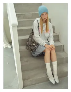 Full view of light blue wool knit beanie paired with a casual hoodie and leopard tote bag