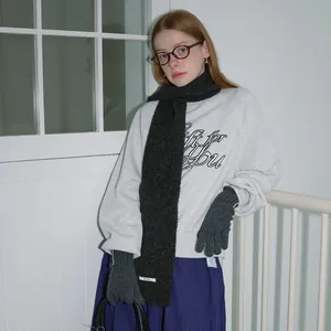 Grijze sweater met wollen sjaal en gebreide handschoenen voor een warme winterlook