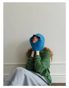Detail of bright blue wool-blend Aran knit balaclava hood with textured cable pattern