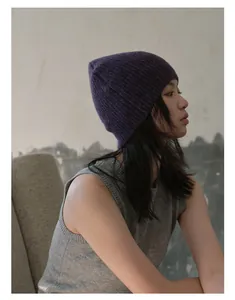 Détails de texture du bonnet en laine mélangée violet foncé avec tricot côtelé