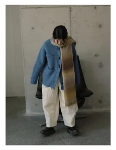 Dettaglio della sciarpa in lana sfumata con frange e cardigan in maglia blu morbida
