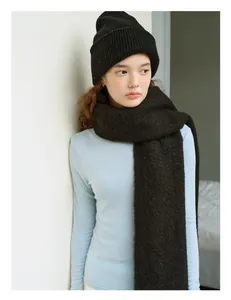 Detalle de la textura gruesa del gorro de punto negro y bufanda de 100% lana pura de oveja