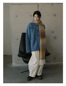 Sciarpa sfumata con nappe abbinata a cardigan blu e pantaloni trapuntati bianchi