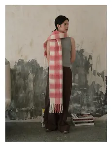 Detail van een dikke roze en witte geruite sjaal met lange kwastjes voor een winterlook