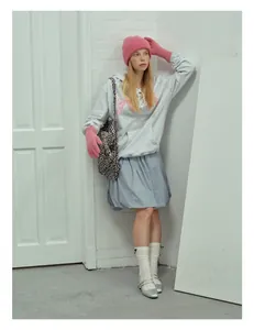 Detail of pink ribbed wool knit beanie paired with matching gloves and a stylish outfit