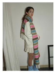 Détail d'une écharpe en laine à rayures multicolores avec des franges douces et tricotées