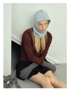 Dettaglio del passamontagna in lana di alpaca azzurra e dei guanti lunghi in maglia grigia