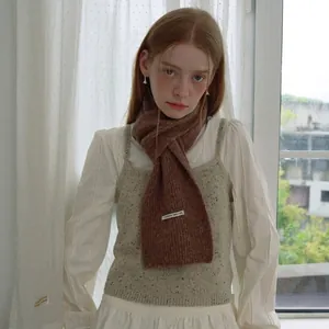 Dunkelbrauner Strickschal aus Alpakawolle-Mix, kombiniert mit einer grauen Strickweste