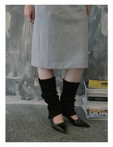 Detail of black wool blend knit leg warmers styled with pointed loafers for autumn fashion