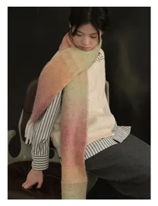 Dettaglio della sciarpa in lana sfumata arcobaleno con morbida trama mohair e frange soffici
