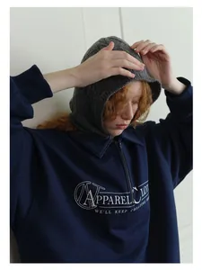 Close-up of grey cable-knit balaclava paired with a navy blue quarter-zip sweatshirt
