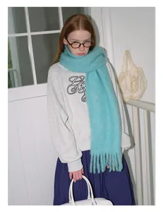 Detailed texture of thick blue wool scarf with tassels and casual grey sweatshirt