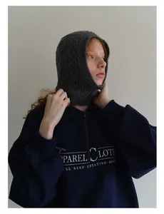 Detail of wool blend knitted balaclava with charcoal texture and graphic sweatshirt