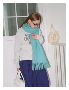 Detail of light cyan wool scarf featuring fluffy texture and delicate fringe trim
