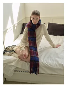 Close-up of wool blend plaid scarf in burgundy and blue with soft tassel fringe details