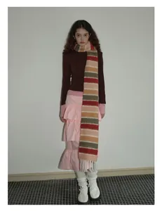 Détail de l'écharpe en laine à rayures colorées avec de longs franges blanches